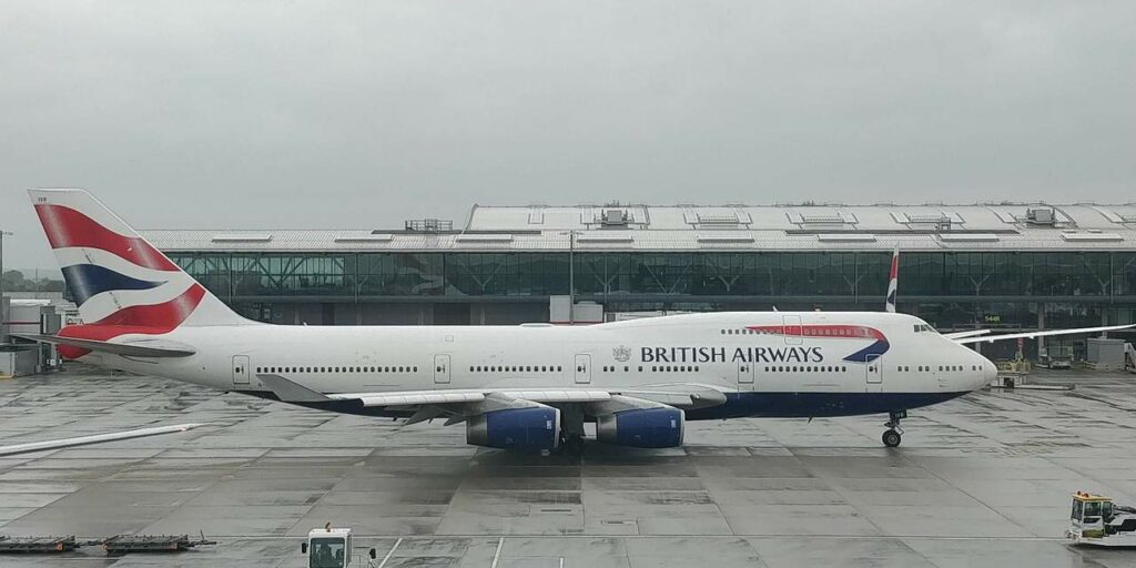 British airways is taxiing on the runway in rainy weather.
